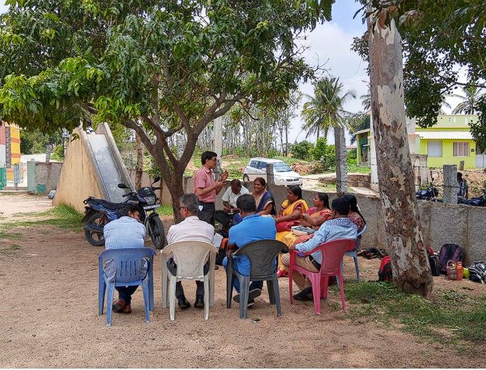 A Vidhyadaanam teacher training session held outdoors under a tree